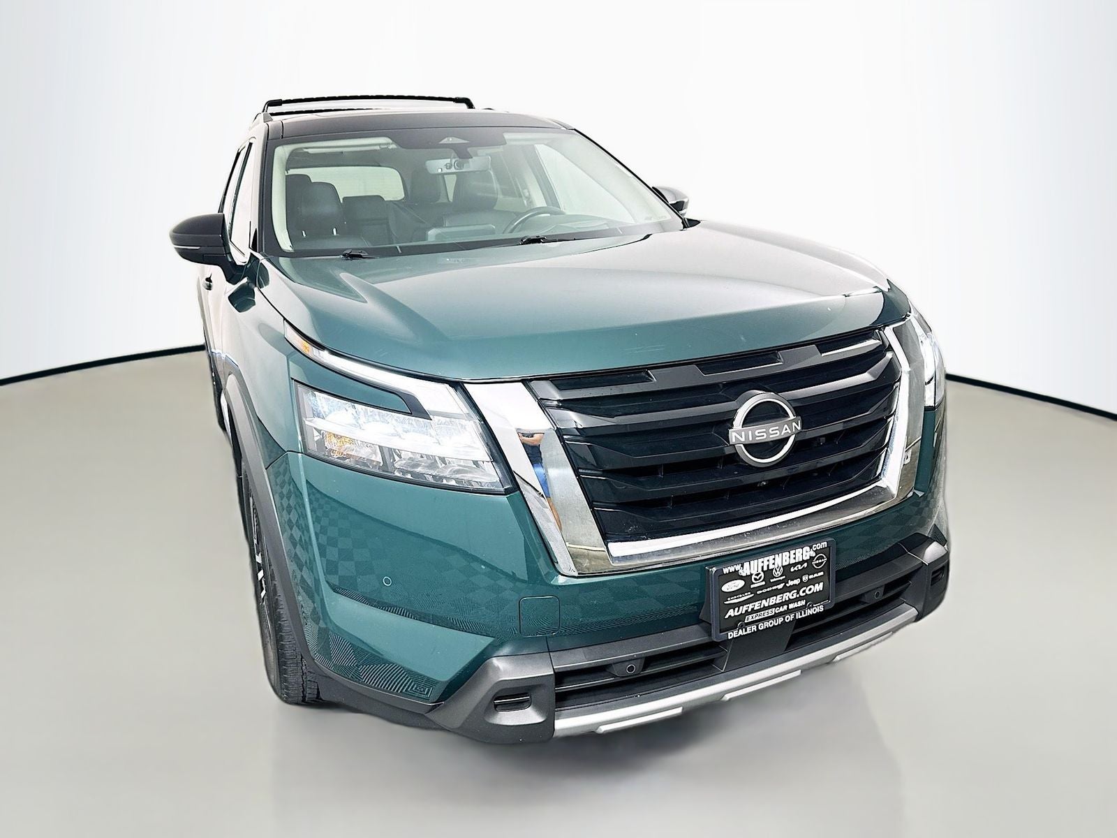2023 Nissan Pathfinder Platinum in Obsidian Green Pearl/Super Black — front three-quarter view